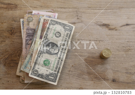 mixed international currency banknotes on rustic wooden table background mixed international currency banknotes on rustic wooden table background 132810783