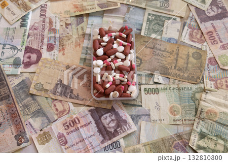pills and capsules in plastic container on international currency 132810800