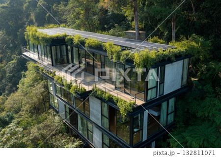 Drone view of green architectural complex with rooftop gardens, solar energy, and lush forest surroundings 132811071