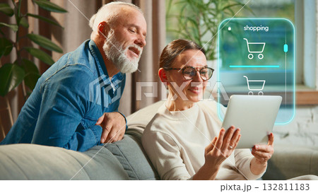 Senior couple online shopping using futuristic digital interface at home. Creative collage 132811183