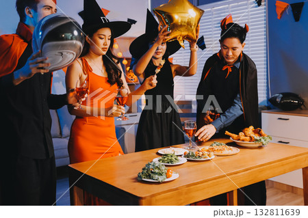 Joyful office Halloween party with coworkers in costumes, celebrating with drinks and laughter, fostering teamwork and festive spirit Joyful office Halloween party with coworkers in costumes, celebrating with drinks and laughter, fostering teamwork and festive spirit 132811639