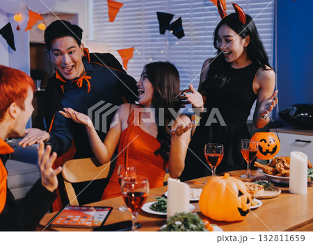 Joyful office Halloween party with coworkers in costumes, celebrating with drinks and laughter, fostering teamwork and festive spirit 132811659