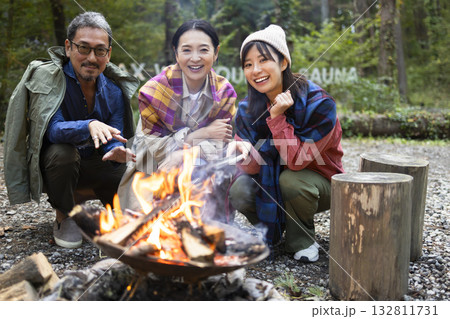 キャンプ場で焚き火をする家族 132811731