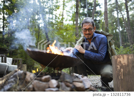 キャンプ場で焚き火をする男性 キャンプ場で焚き火をする男性 132811736
