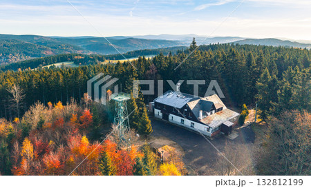 Experience the stunning autumn colors surrounding Slovanka Lookout Tower, a historic iron structure nestled in the Jizera Mountains. Enjoy scenic views and serene forest landscapes. 132812199
