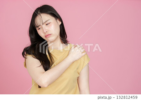 Health. Young woman experiencing shoulder pain, expressing discomfort. Health. Young woman experiencing shoulder pain, expressing discomfort. 132812459
