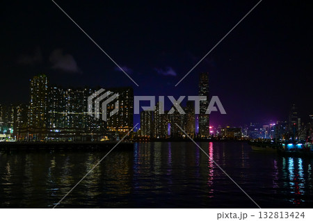 The night view of Hong Kong Island from the Kowloon. Hong Kong cityscape and seascape at night. Nature and city scene. 132813424