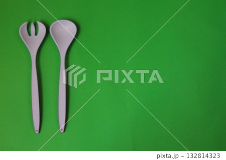white fork and spoon on green background. white fork and spoon on green background. 132814323