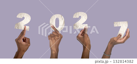 2027 new year celebration concept. Hand with raised fingers holding silver metallic number collage, 132814382