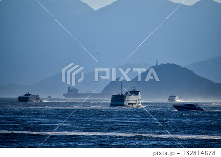 The view of the sea in the sunny day with blue sky and mountain and ships in the background. Calm sea and water. Sea background, wave pattern. Nature concept. 132814878