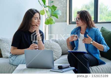 Serious teen girl in session in office of professional psychologist, therapist Serious teen girl in session in office of professional psychologist, therapist 132815109