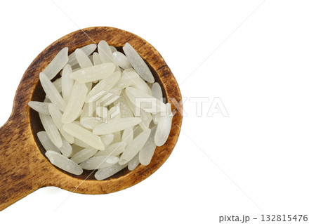 Raw white rice on wooden background. Long uncooked rice in wooden plate. Natural organic food. Traditional Asian cereal culture. Raw white rice on wooden background. Long uncooked rice in wooden plate. Natural organic food. Traditional Asian cereal culture. 132815476