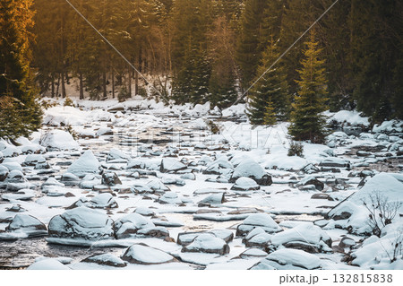 A peaceful winter evening at Jizera River, where snow blankets smooth rocks and trees. The serene atmosphere reflects the beauty of nature along the border of Czechia and Poland. A peaceful winter evening at Jizera River, where snow blankets smooth rocks and trees. The serene atmosphere reflects the beauty of nature along the border of Czechia and Poland. 132815838