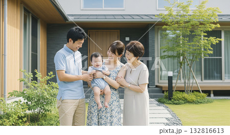 住宅の前で笑顔で赤ちゃんを囲む三世代家族 132816613