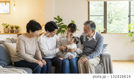 リビングで笑顔で赤ちゃんを囲む三世代家族 132816614