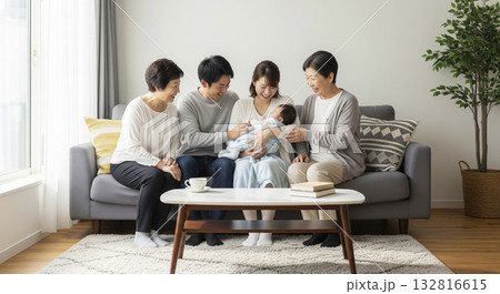 リビングで笑顔で赤ちゃんを囲む三世代家族 132816615