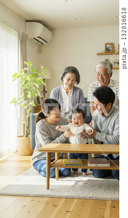 リビングで笑顔で赤ちゃんを囲む三世代家族 132816618