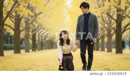 黄葉したイチョウ並木を男女2人で歩く 132816625