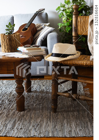 Cozy rustic living room with guitar and straw hat 132816684
