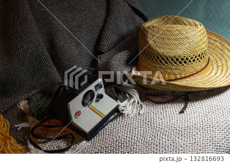 Travel preparations with straw hat and vintage instant camera. Horizontal shot. Copy space 132816693