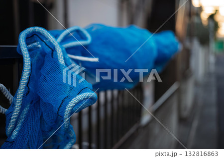 住宅の柵に巻きつけられた青い防風ネット 132816863