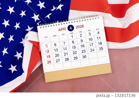 April 2026 Monthly desk calendar and United States of America flag. 132817136
