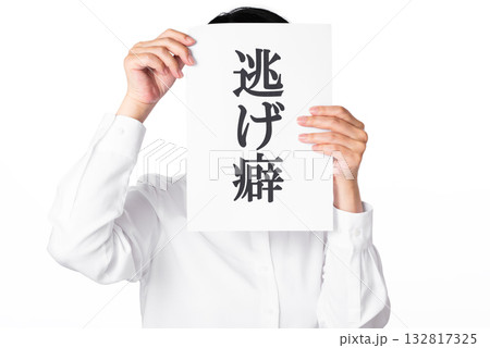 逃げ癖と書かれた紙を両手で掲げる白いシャツを着た人物 132817325