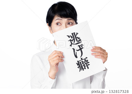 逃げ癖と書かれた紙を持ち視線を送る白いシャツを着たシニア女性 逃げ癖と書かれた紙を持ち視線を送る白いシャツを着たシニア女性 132817328