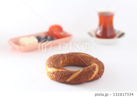 Turkish bagel, simit, tomatoes & Turkish tea on white background. Turkish bagel, simit, tomatoes & Turkish tea on white background. 132817334