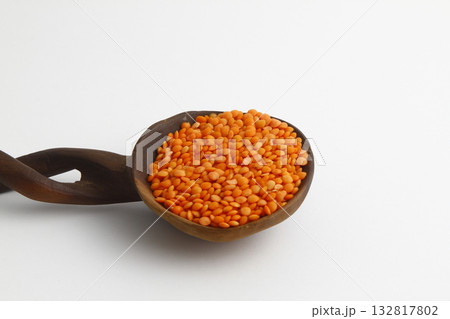red lentils in wooden spoon isolated on white background. Top view. red lentils in wooden spoon isolated on white background. Top view. 132817802