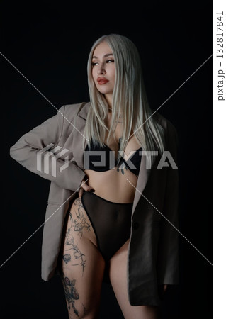 Model posing confidently in stylish attire against a dark background 132817841