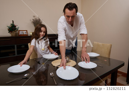 Father And Daughter Prepare Dinner Table In Cozy Home, A Warm Family Moment Father And Daughter Prepare Dinner Table In Cozy Home, A Warm Family Moment 132820211