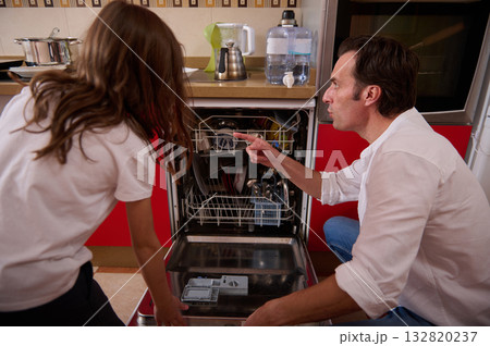 Father And Daughter In Kitchen Helping With Dishwasher Load After Dinner Father And Daughter In Kitchen Helping With Dishwasher Load After Dinner 132820237