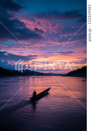 A long-tail boat navigating the tranquil Mekong River at sunset, its silhouette against a dramatic, colorful sky, portraying peaceful travel. 132820565