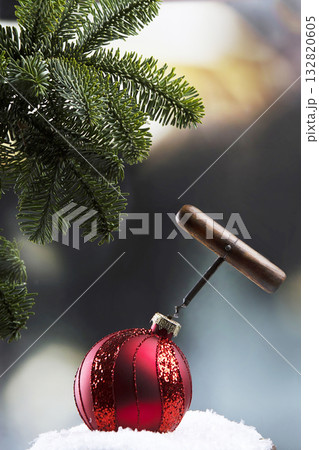 Corkscrew and Christmas red ball to decorate Christmas tree. Concept of the beginning of New Year holiday. Copy space. Corkscrew and Christmas red ball to decorate Christmas tree. Concept of the beginning of New Year holiday. Copy space. 132820605