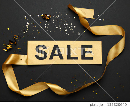 A bold Sale banner is draped across a plain black background with confetti and sparkles. 132820640