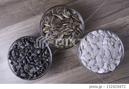 Various seeds in glass bowls on a wooden table. Various seeds in glass bowls on a wooden table. 132820872