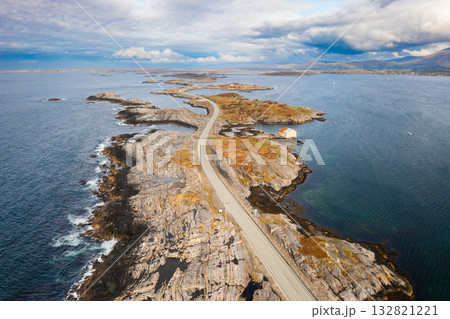 Magnificent Atlantic ocean road snakes across small islands and skerries. Grey sky and calm water emphasize vastness of Norwegian coastal landscape 132821221