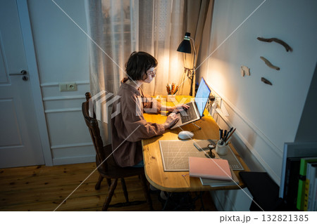 Focused busy woman working late. Tired concentrated young female typing laptop at home at night 132821385