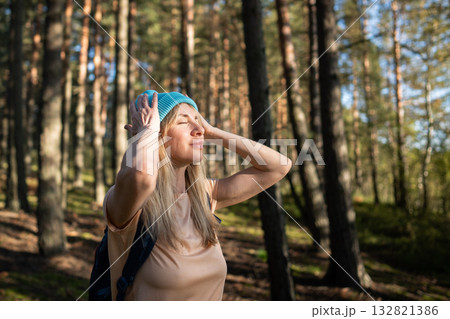 Female meditating in woods deep breath of fresh air. Mindful nature travel, woman rest in forest 132821386
