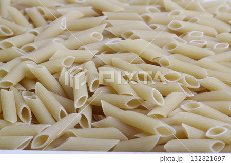 Delicious pasta, penne noodles background. Top view scene, healthy eating or healthy lifestyle. Penne Delicious pasta, penne noodles background. Top view scene, healthy eating or healthy lifestyle. Penne 132821697