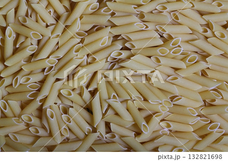 Delicious pasta, penne noodles background. Top view scene, healthy eating or healthy lifestyle. Penne Delicious pasta, penne noodles background. Top view scene, healthy eating or healthy lifestyle. Penne 132821698