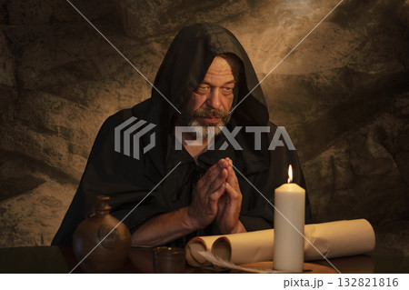 Handwriting and prayer in ancient times - a scene with a monk and parchment. Handwriting and prayer in ancient times - a scene with a monk and parchment. 132821816