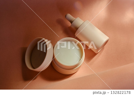 Face cream and serum on a soft beige background. Face cream and serum on a soft beige background. 132822178