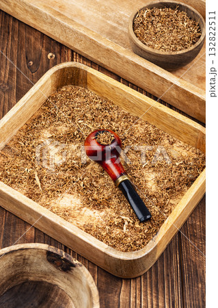 Smoking pipe with tobacco on a table. 132822511