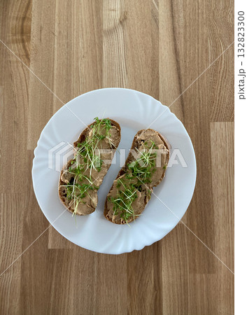 Minimalist homemade snack on wooden table with plant-based spread and fresh greens. Healthy eating, simplicity, and clean aesthetic lifestyle. Minimalist homemade snack on wooden table with plant-based spread and fresh greens. Healthy eating, simplicity, and clean aesthetic lifestyle. 132823300