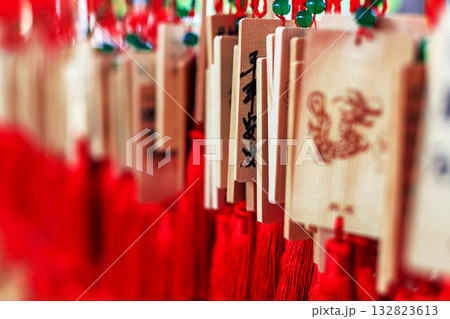 Wooden signs with Chinese characters and dragon designs, decorated with bright red tassels Wooden signs with Chinese characters and dragon designs, decorated with bright red tassels 132823613