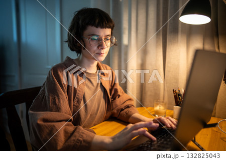 Stressed exhausted woman working late. Tired female typing on laptop night hours in stress at home Stressed exhausted woman working late. Tired female typing on laptop night hours in stress at home 132825043