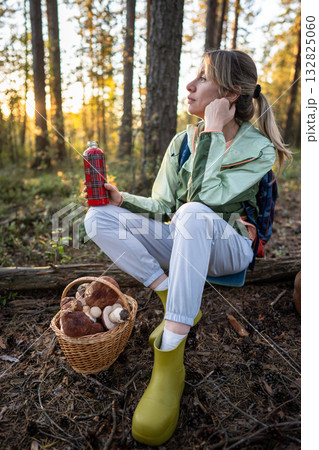 Relaxed thoughtful woman enjoying nature in forest sipping tea after mushroom foraging, look away Relaxed thoughtful woman enjoying nature in forest sipping tea after mushroom foraging, look away 132825060