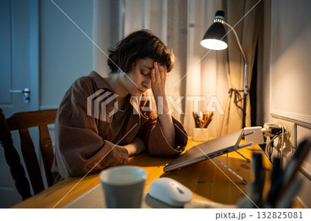 Sleepy exhausted young woman cradles face in hands after night work. Overwhelmed millennial 132825081